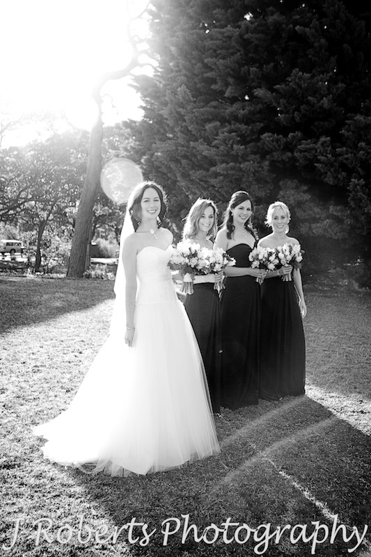 Bride with the sun behind her and her bridesmaids pre wedding - wedding photography sydney